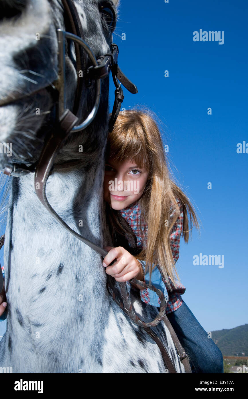 Mixed race girl riding horse on ranch Stock Photo