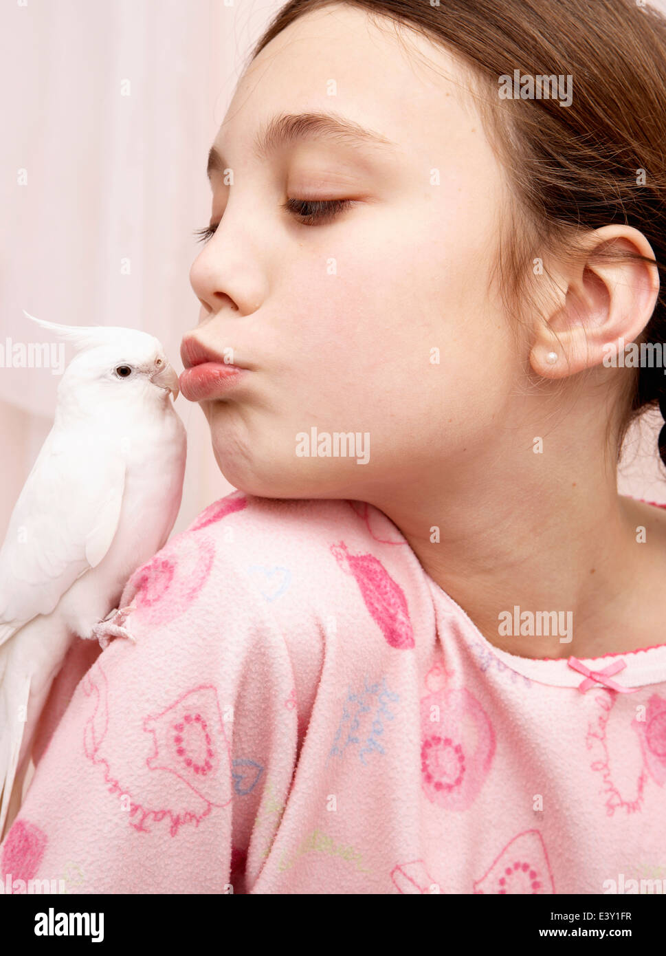 Mixed race girl kissing bird Stock Photo