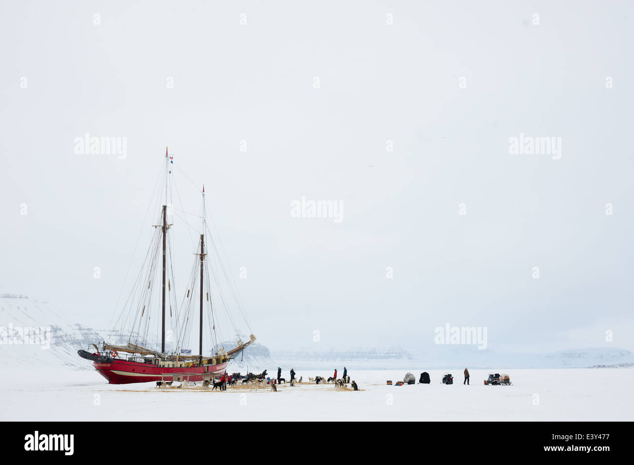 Dog sled teams and snowmobiles on the ice in front of the Noorderlicht