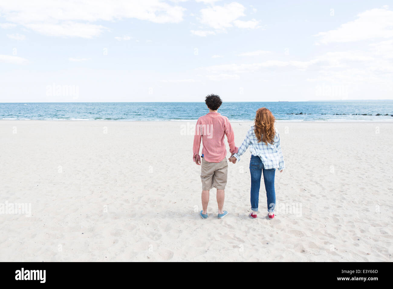 Couple holding hands on beach hi-res stock photography and images - Alamy