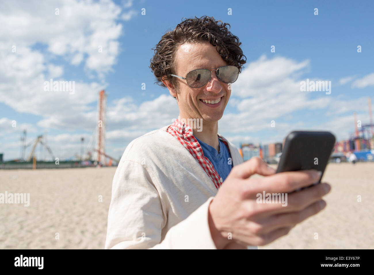 Mid adult man texting on smartphone at beach Stock Photo - Alamy