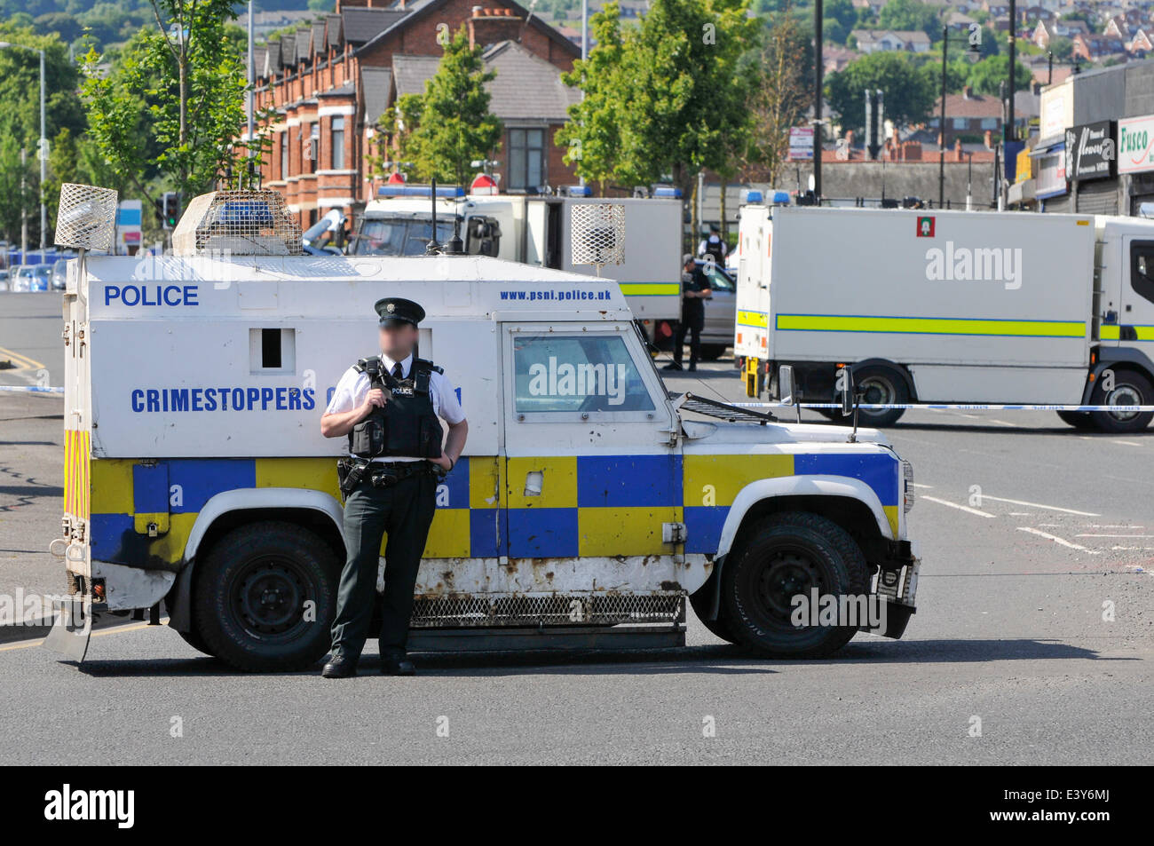 Belfast, Northern Ireland. 1 Jul 2014 - PSNI Landrover blocks the Crumlin Road as army ATO (bomb squad) make safe a pipe bomb found on the roof of a shop in Ardoyne, North Belfast. Credit:  Stephen Barnes/Alamy Live News Stock Photo