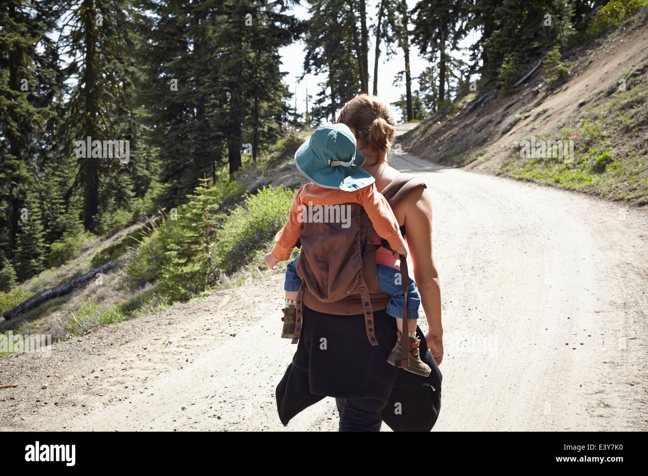 Rear view of mother carrying toddler in baby carrier Stock Photo