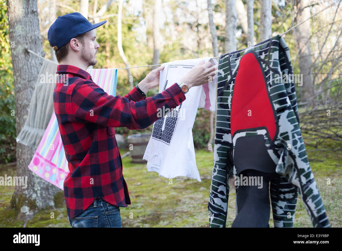 Mid adult man hanging out laundry in garden Stock Photo