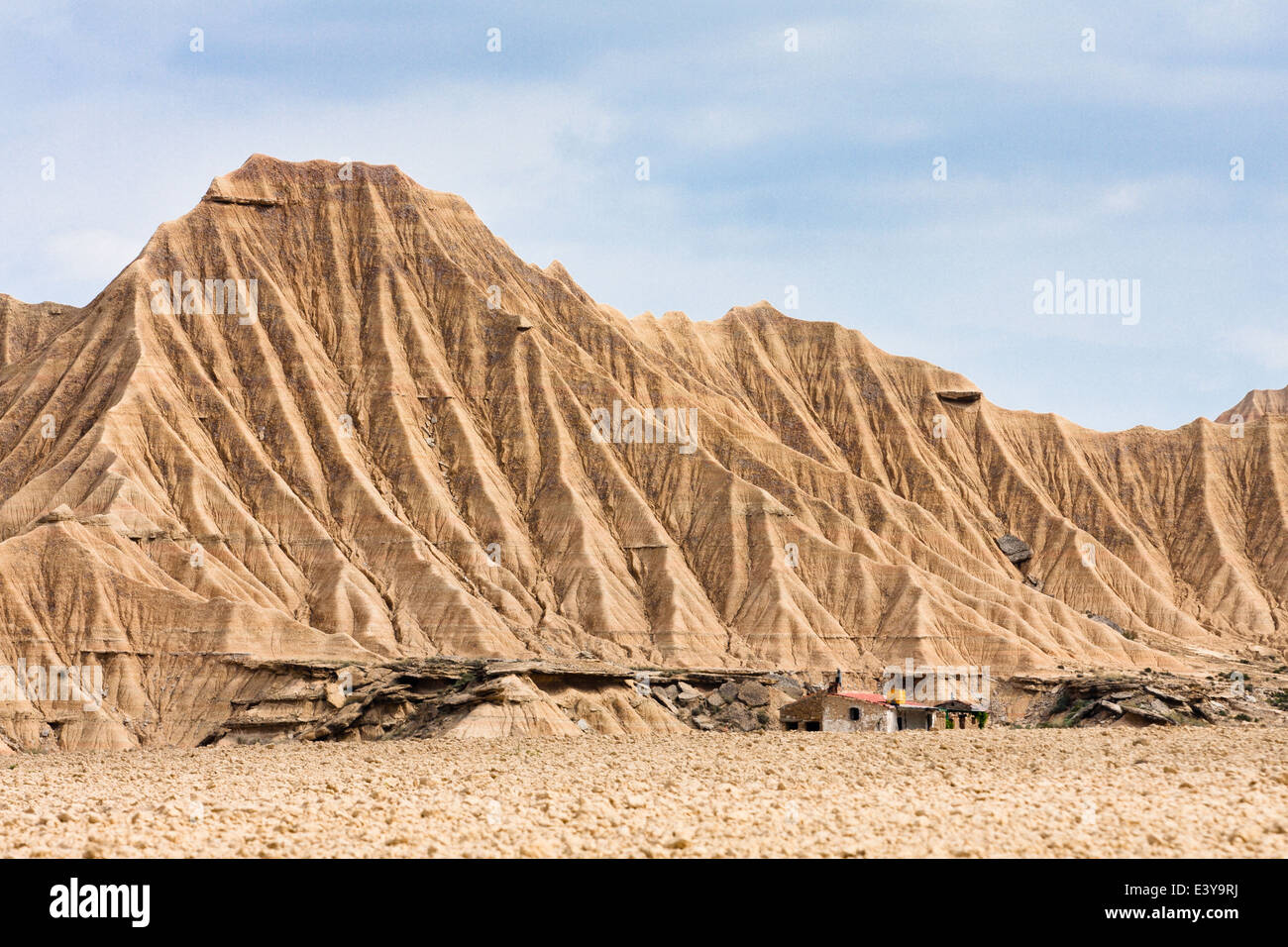 Old house in front of big mountains of Bardenas Reales, Navarra Stock Photo