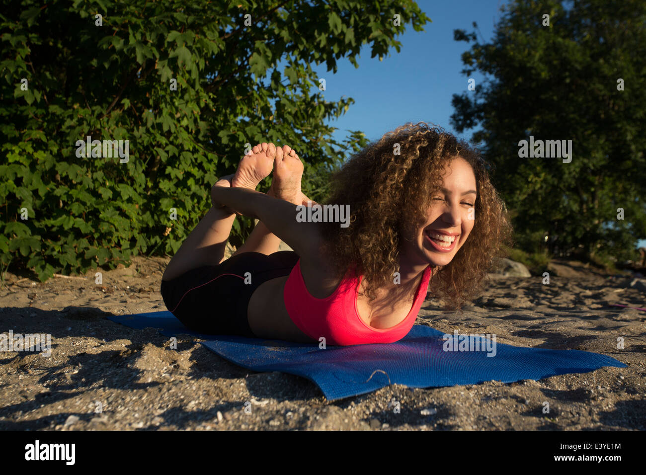 Smiling girl Doing Yoga on the Beach. Stock Photo