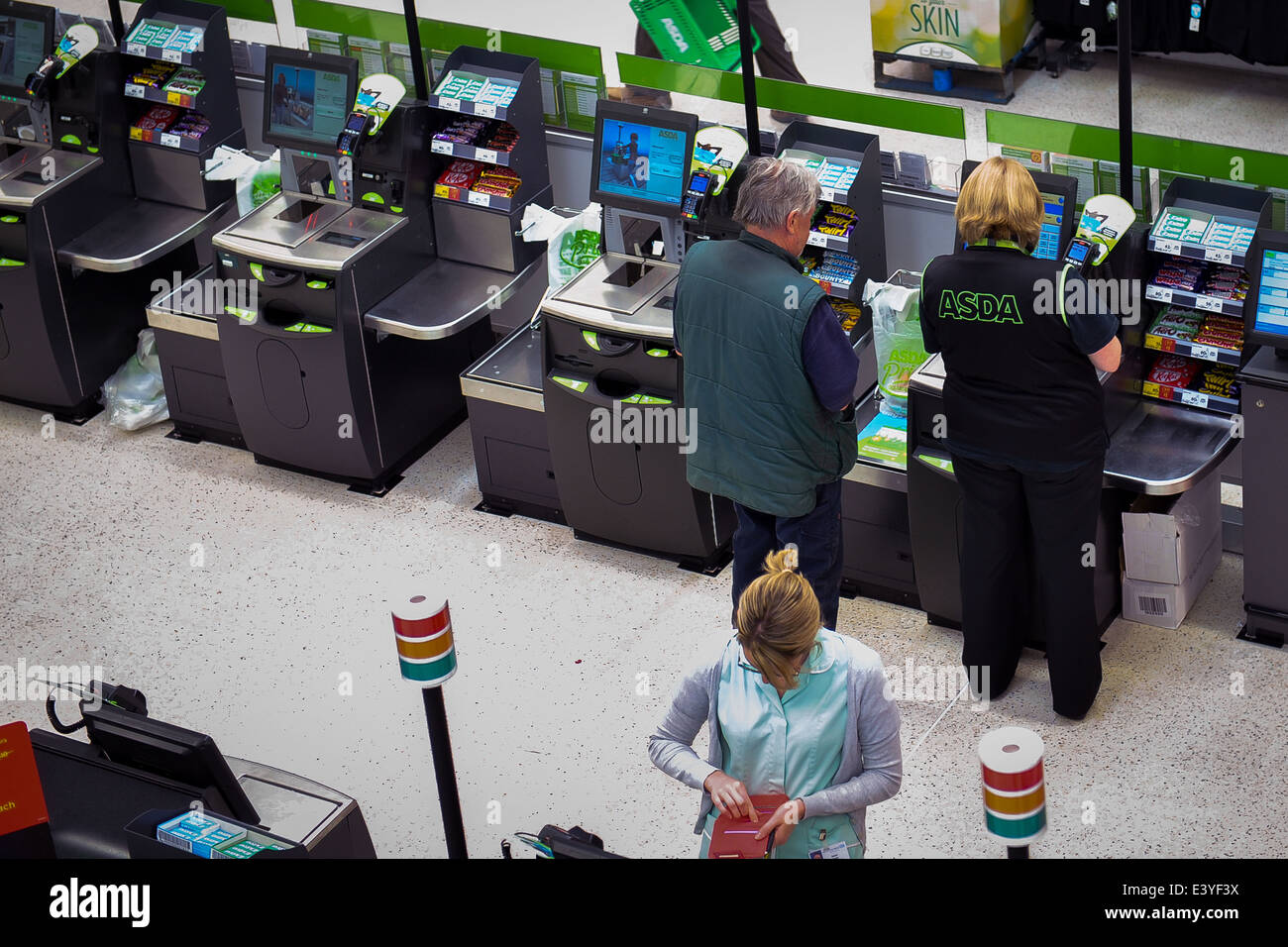 Man getting help with self service till in supermarket Stock Photo