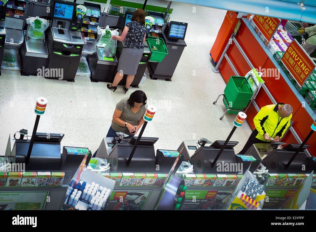 3 people shopping at supermarket self-service check-outs Stock Photo