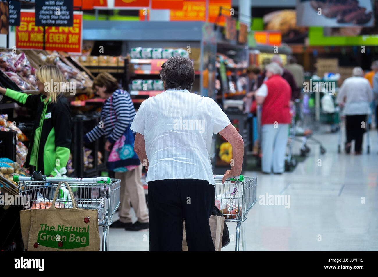customer walking down fresh produce aisle of supermarket Stock Photo