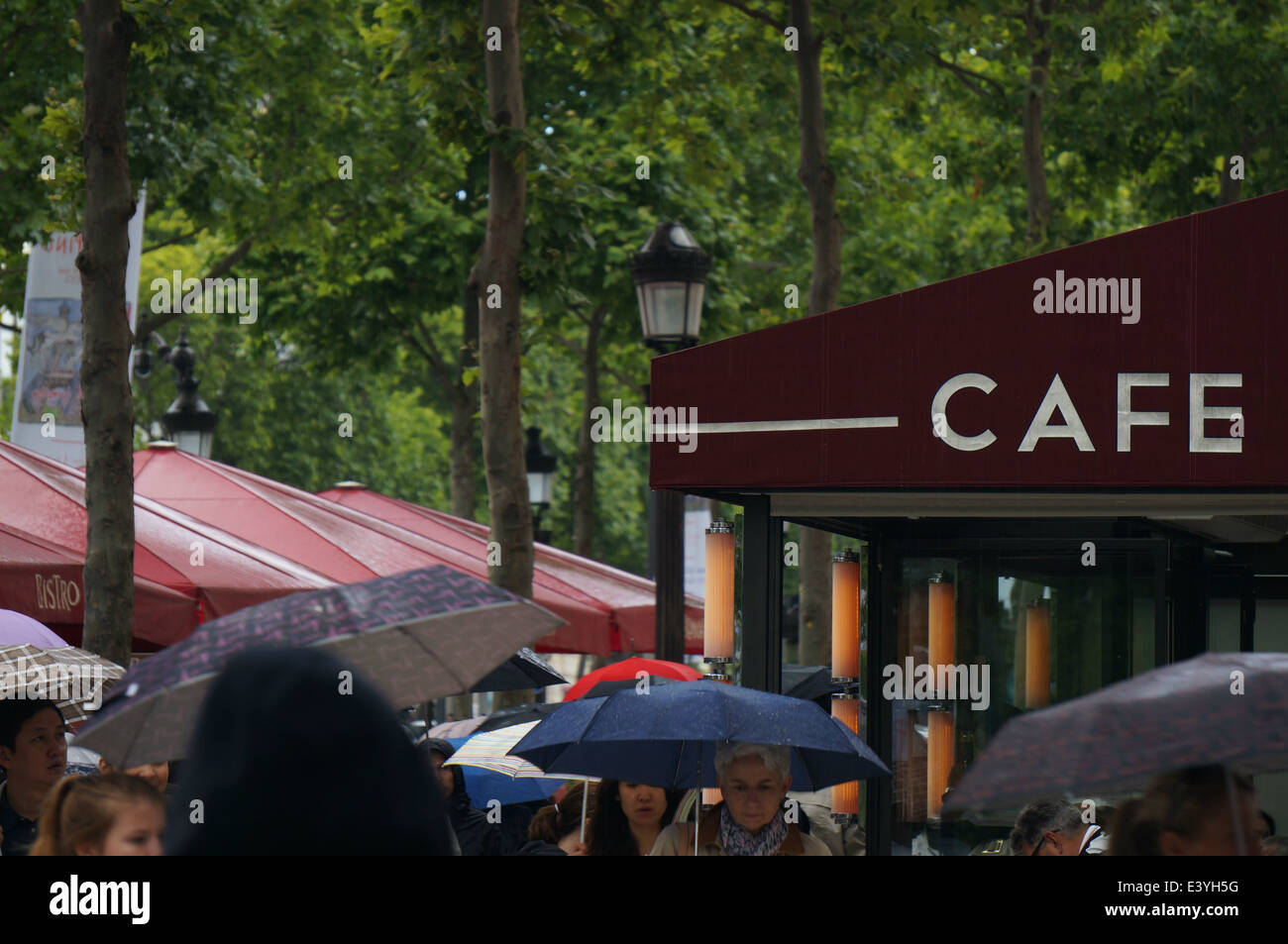 A crowd of umbrellas in front of Cafe George V and Bistro Romain on Avenue des Champs Elysees Paris in the rain Stock Photo