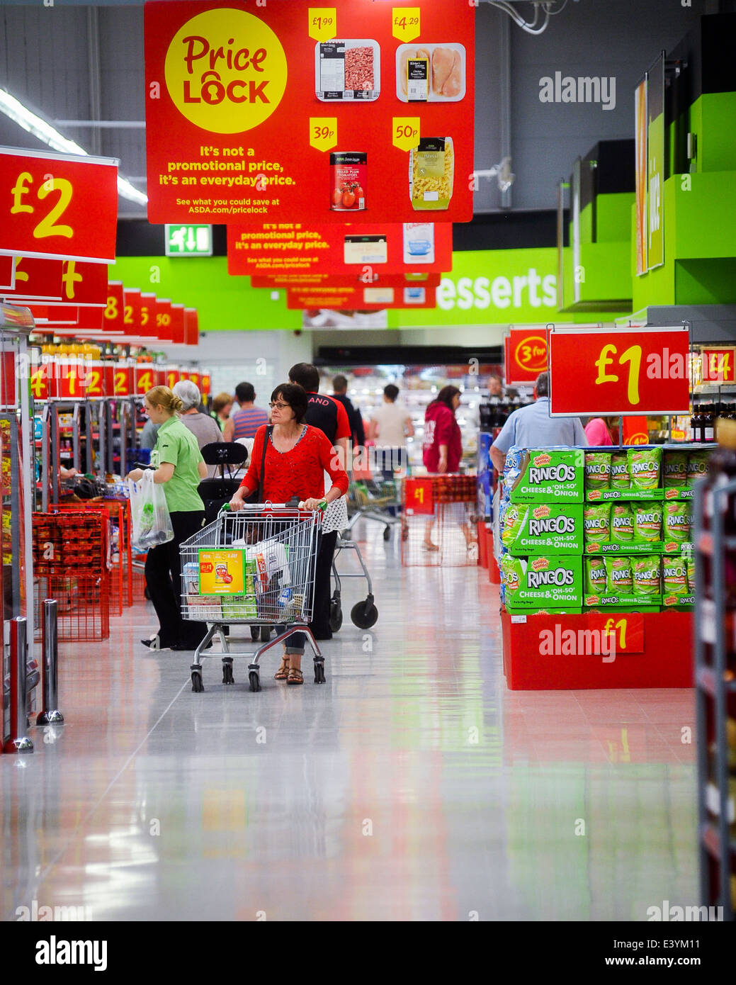 People walking around a supermarket with discount signs in the aisles Stock Photo