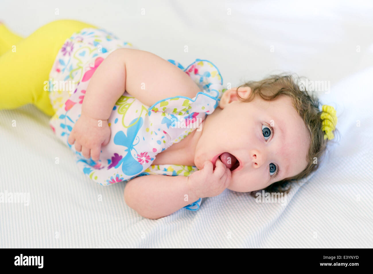 A three month old Caucasian infant chewing on her fingers while teething. USA. Stock Photo