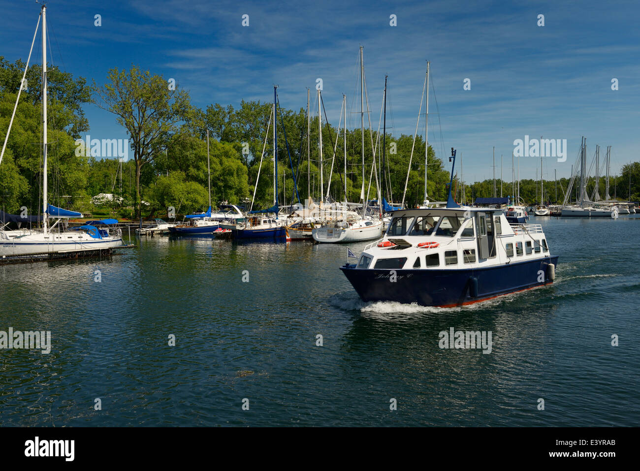 Boat leaving Toronto Island Yacht Club marina on Muggs Island on Lake Ontario Stock Photo