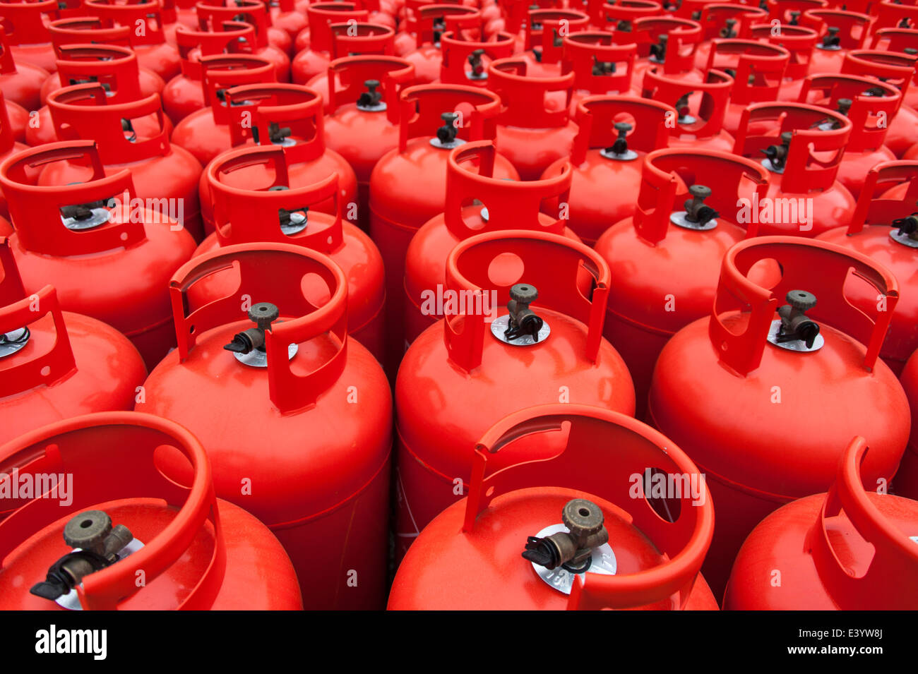 Details of red gas bottles stacked at a storage depot. Stock Photo