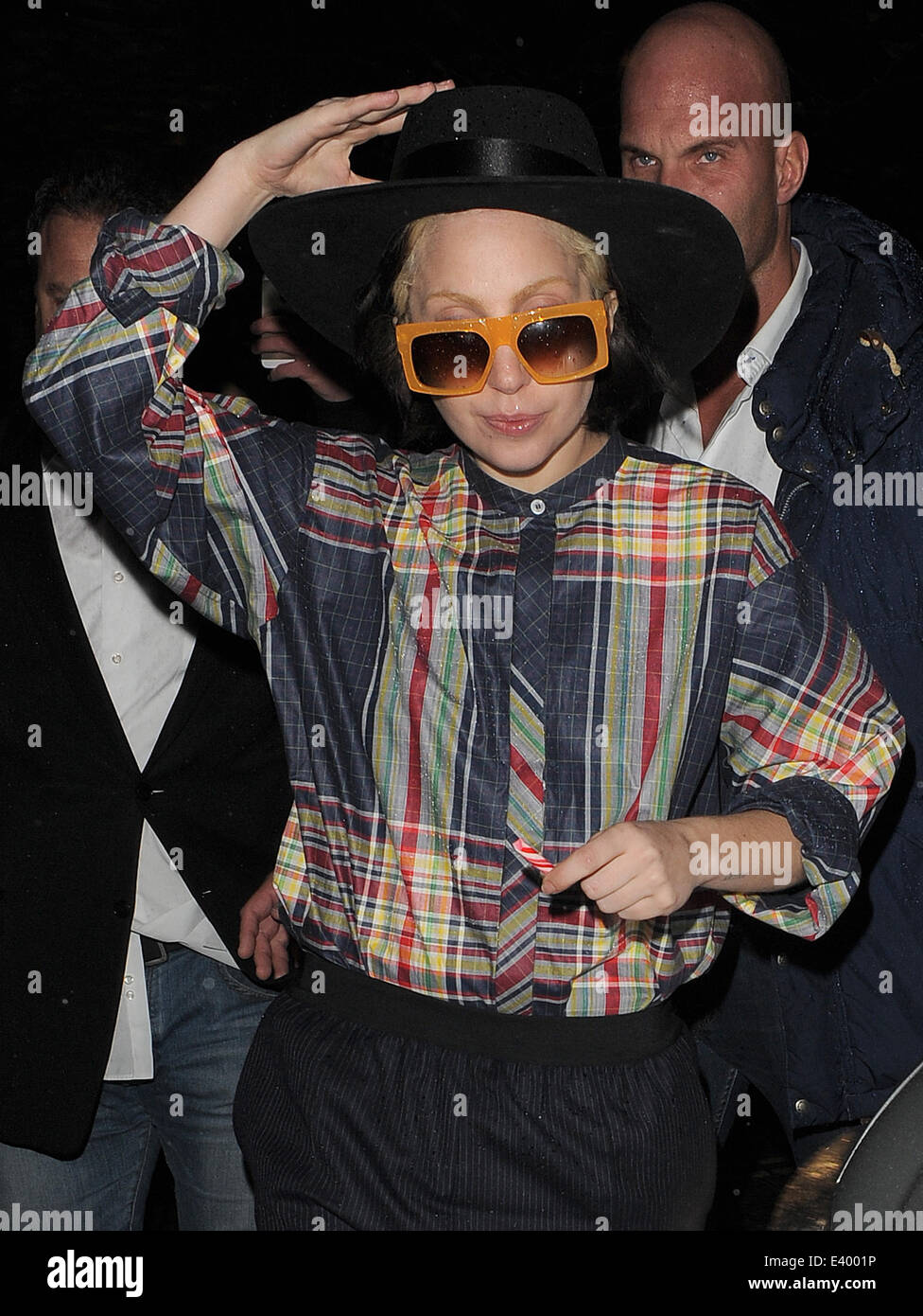 Lady Gaga returns to her hotel, wearing a cowboy hat and checked shirt