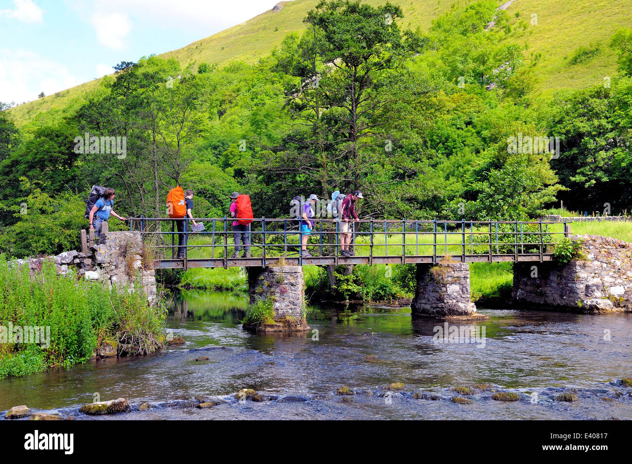 Monsal Dale, walkers on the bridge crossing the River Wye Derbyshire Peak District National Park England UK Stock Photo