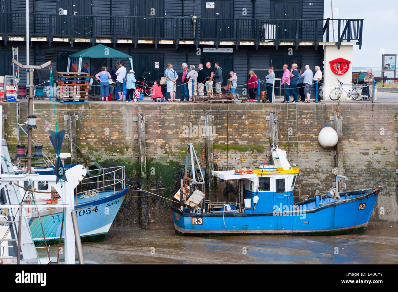 People queuing to buy fresh fish on the quay Whitstable harbour