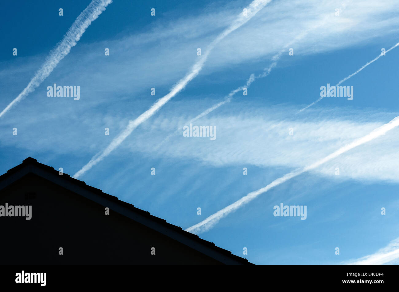 roofline and vapour trails,trails, vapour, planes, vapor, sky, travel, steam, busy, lines, airplane, blue, aircraft, flight, fly Stock Photo