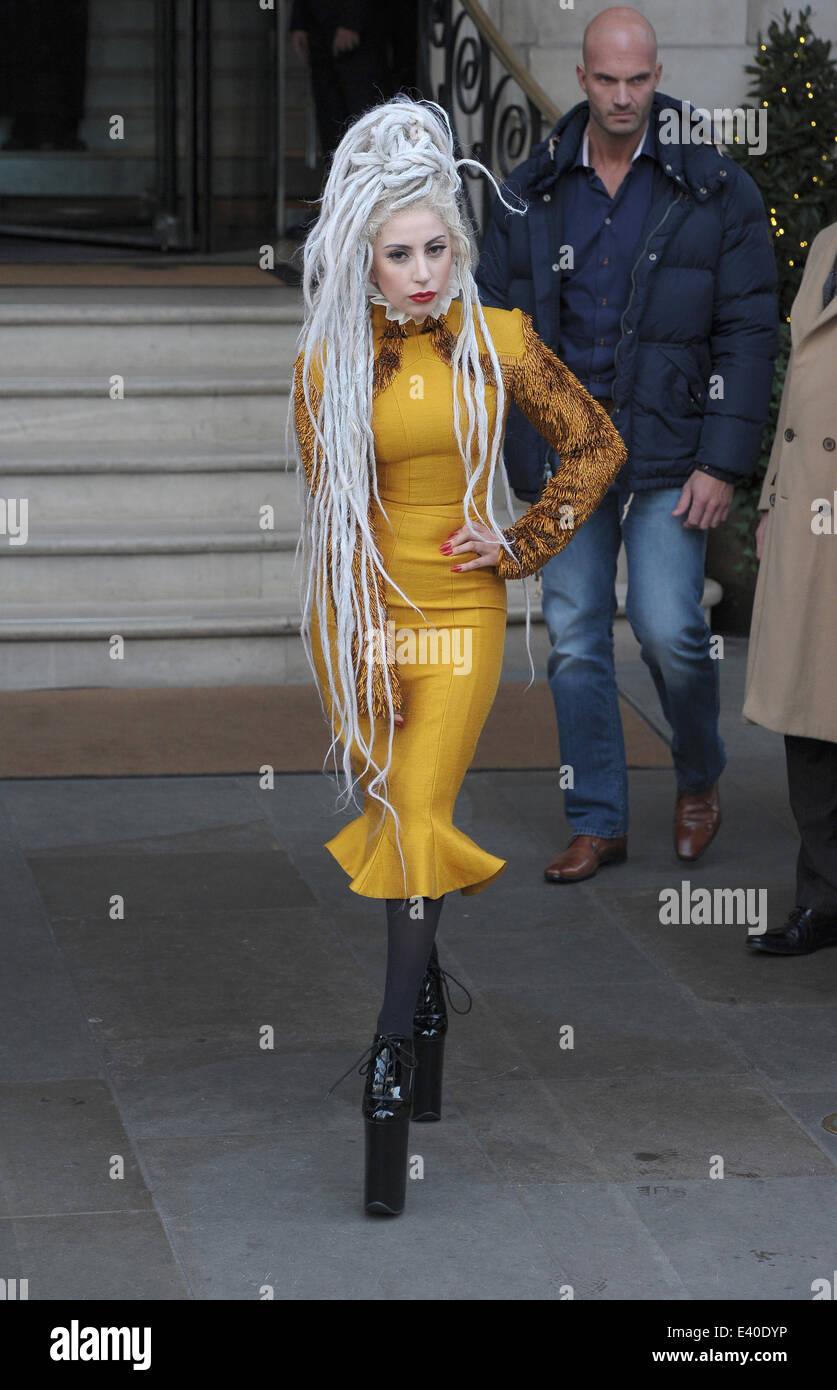 Lady Gaga leaving her hotel wearing a yellow dress and with her