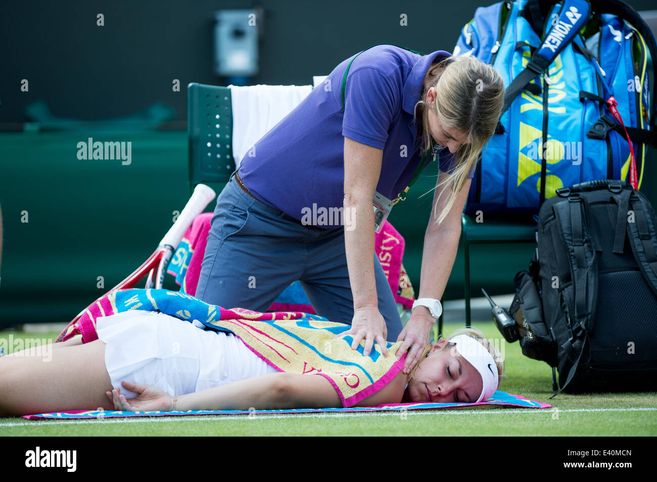 Wimbledon, London, UK. 1st July, 2014. Tennis: Wimbledon Championship 2014, Sabine Lisicki of Germany getting medical attention from her trainer during her Ladies' Singles fourth round match against Yaroslava Shvedova of Kazakhstan on day eight of the Wimbledon Lawn Tennis Championships at the All England Lawn Tennis and Croquet Club at Wimbledon on July 1, 2014, London, England. Credit:  dpa picture alliance/Alamy Live News Stock Photo