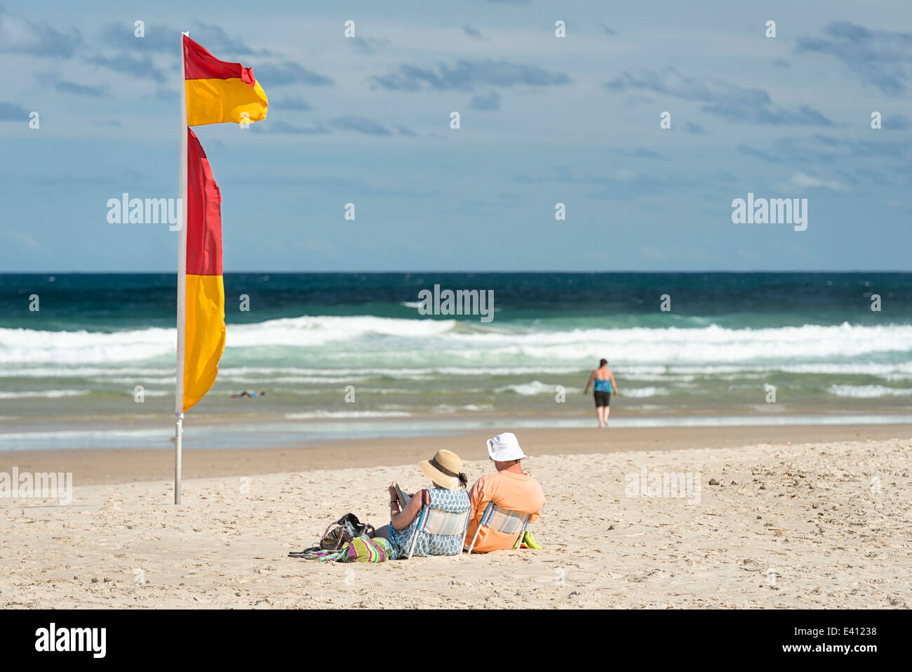 Australia, New South Wales, Pottsville, beach with saftey flag and tourists reading Stock Photo ...