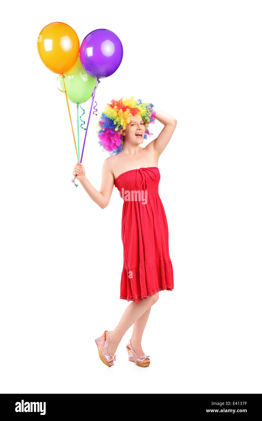 Full length portrait of a silly woman with wig holding balloons Stock Photo