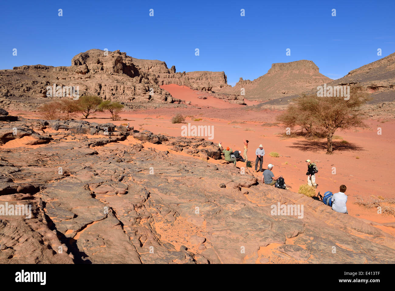 Algeria, Sahara, Tassili N'Ajjer National Park, Tadrart region, Group of people resting at Oued Bouhadian Stock Photo