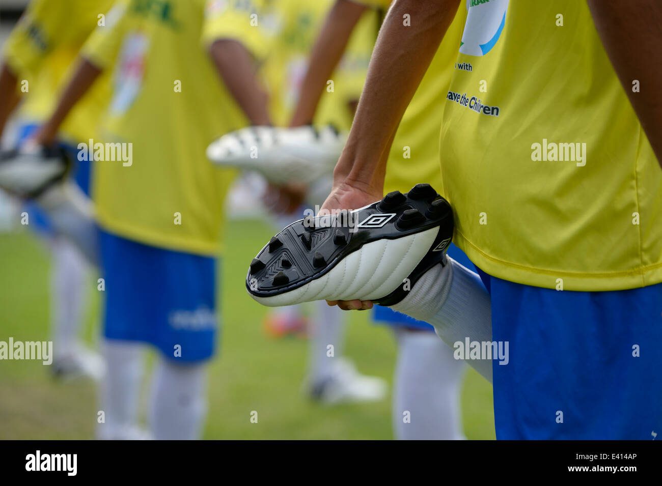 Brazil, Rio de Janeiro, football team of Street Child World Cup 2014 making stretching exercises, partial view Stock Photo