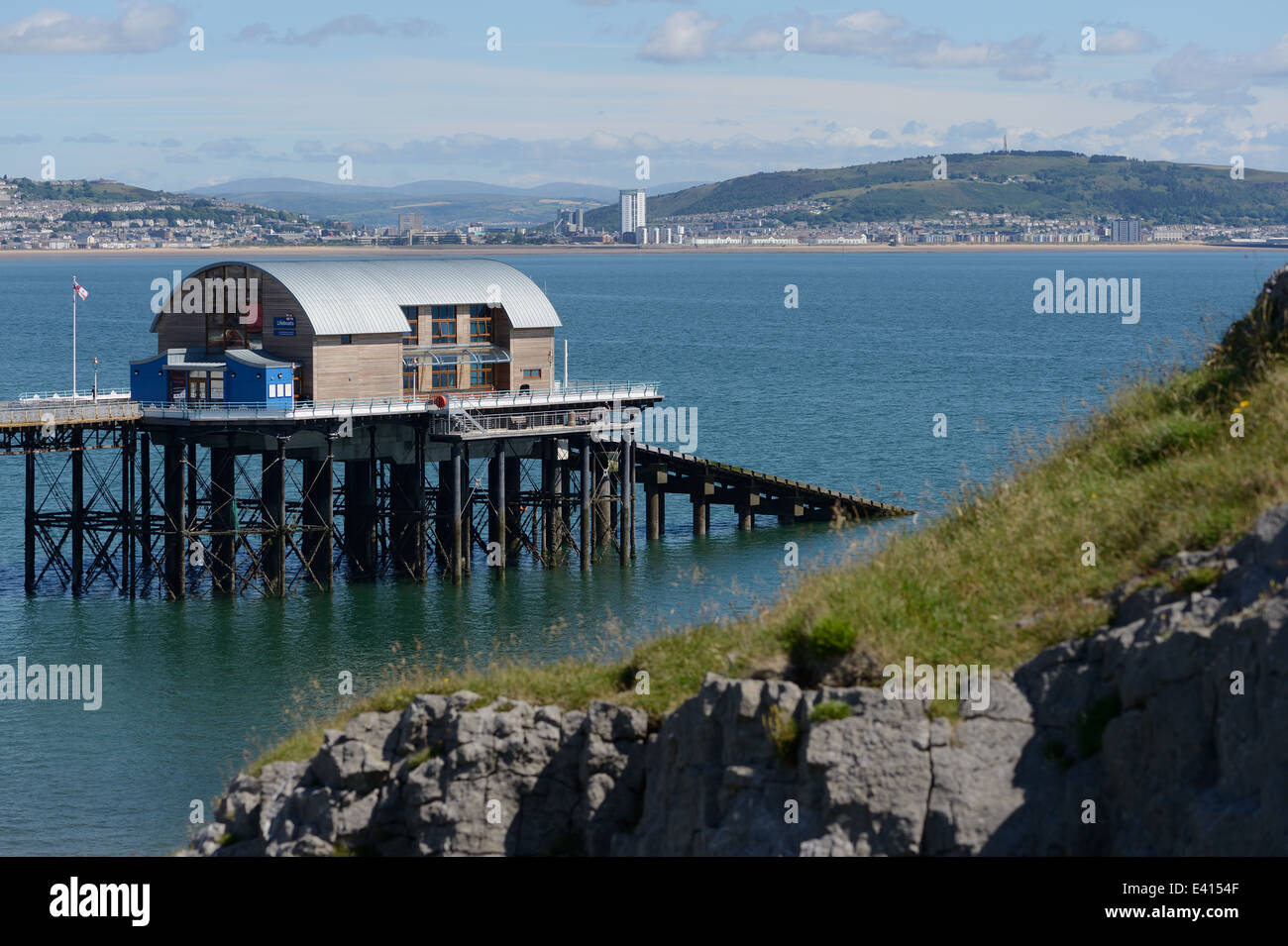 Mumbles lifeboat station with Swansea city ibackground  clear blue water, views to the Brecons, limestone cliff. Mumbles was voted best place to live. Stock Photo