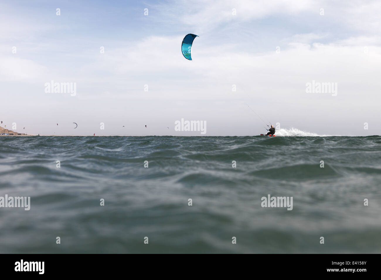 Half underwater photo of man kitesurfing at speed on the horizon of the lagoon in Dakhla, Western Sahara, Morocco Stock Photo