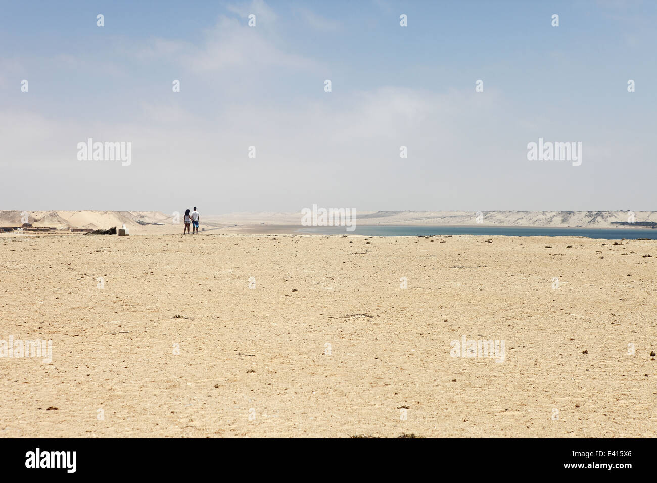 A couple enjoy the view North of the lagoon from above Spirit Camp accommodation in Dakhla, Western Sahara, Morocco Stock Photo