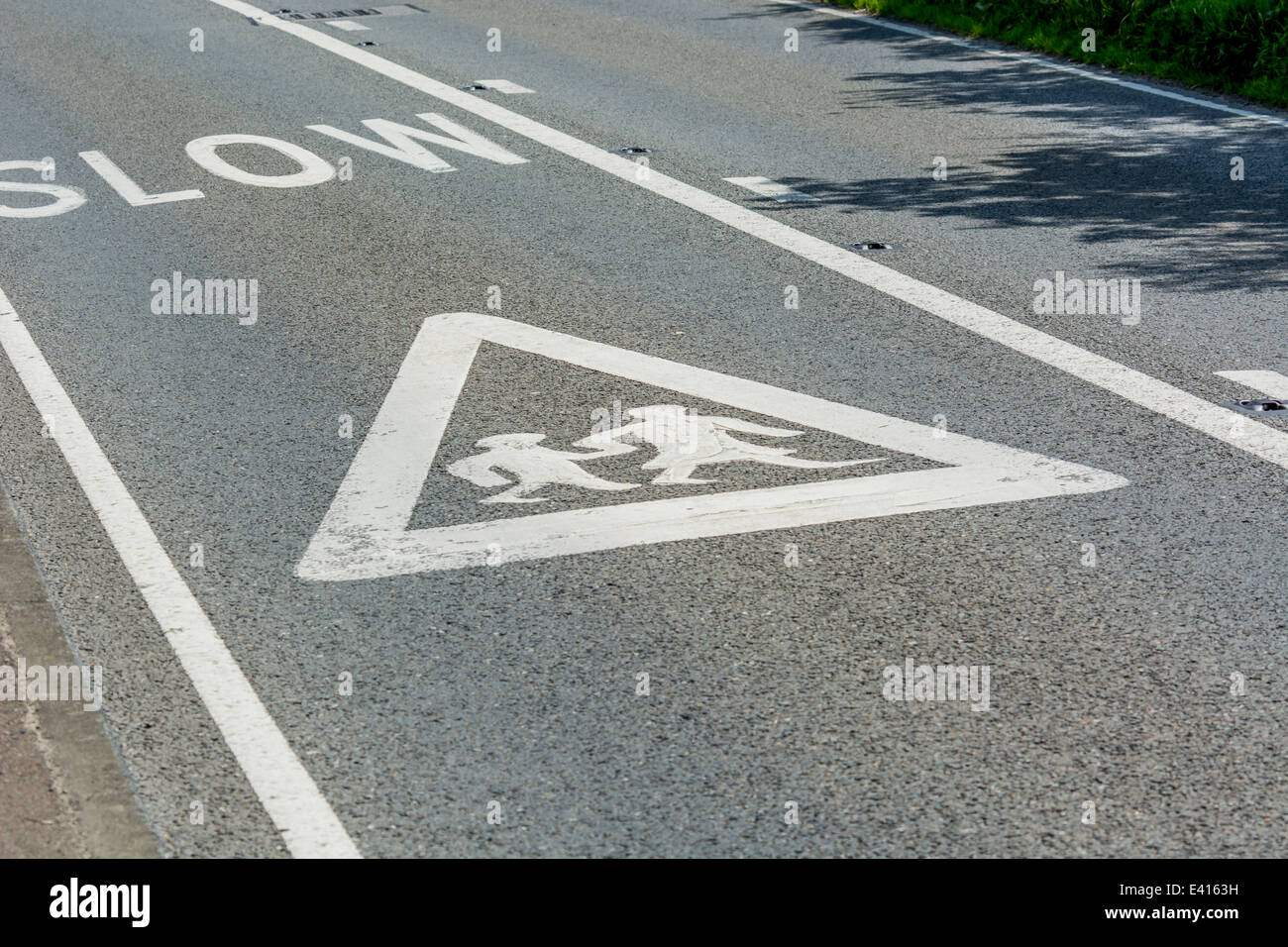 School warning sign on road showing pictogram of girl and boy walking to school pictogram. Metaphor returning to school, new term, term starting. Stock Photo