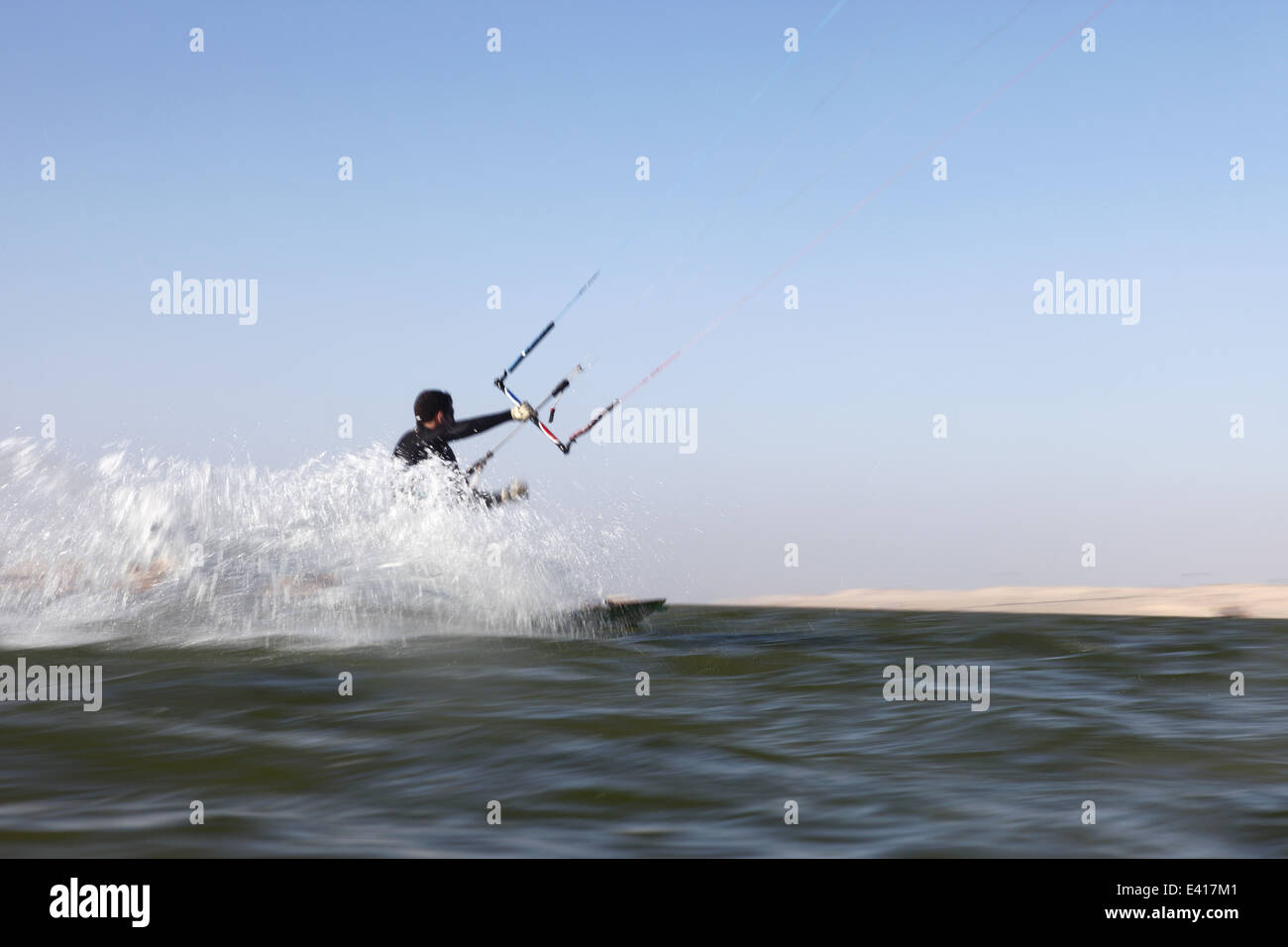 Man kitesurfing at speed on the horizon of the lagoon in Dakhla, Western Sahara, Morocco Stock Photo