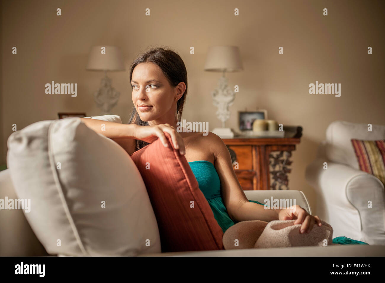 Young contemplative woman sitting in armchair Stock Photo