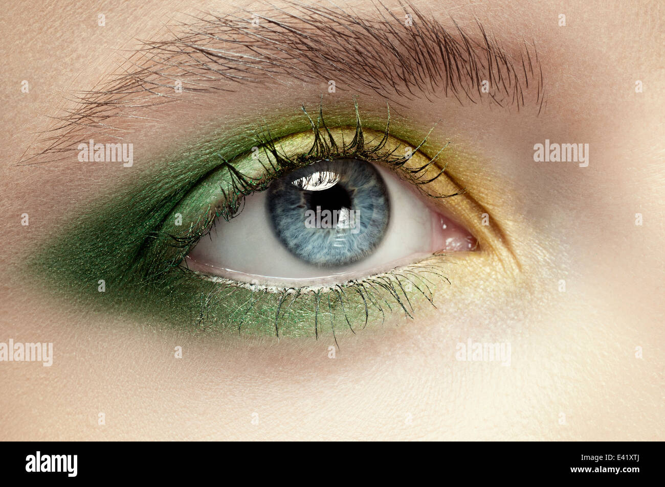 Macro of blue eye with green and yellow eye shadow Stock Photo Alamy