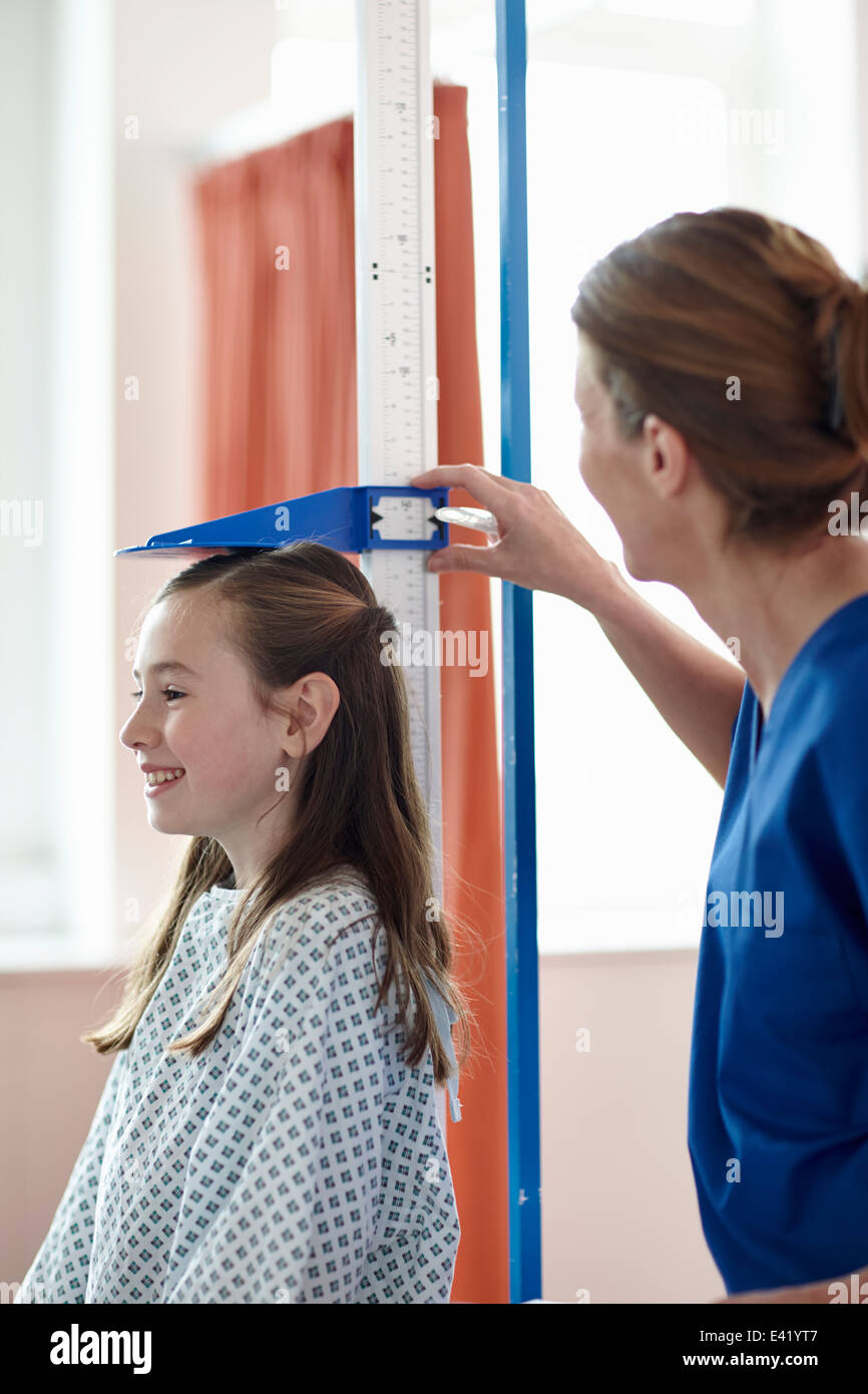 Nurse checking girl's height Stock Photo