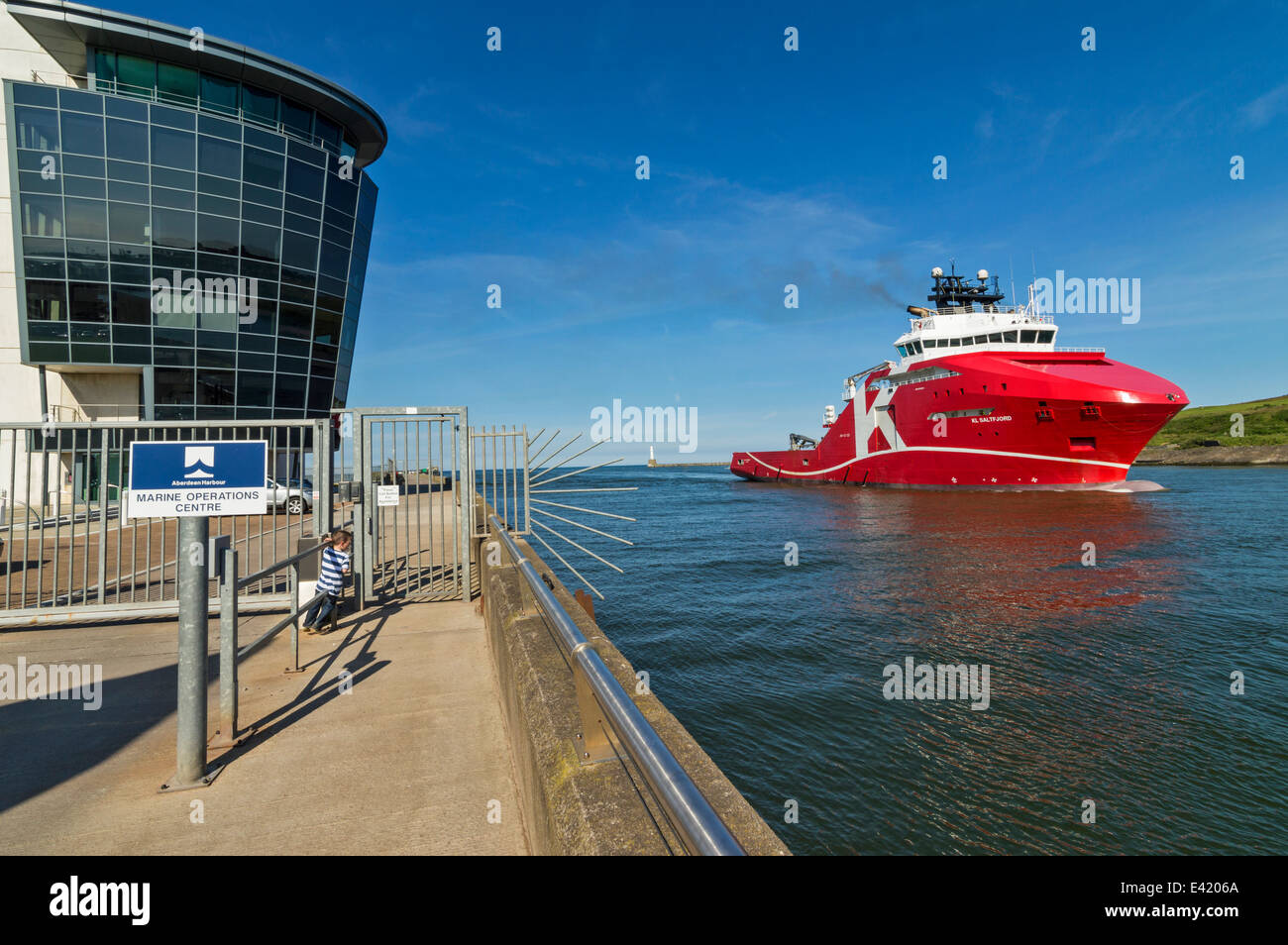 RED NORTH SEA OIL SHIP PASSING THE MARINE OPERATIONS CENTRE NORTH PIER ABERDEEN HARBOUR SCOTLAND Stock Photo