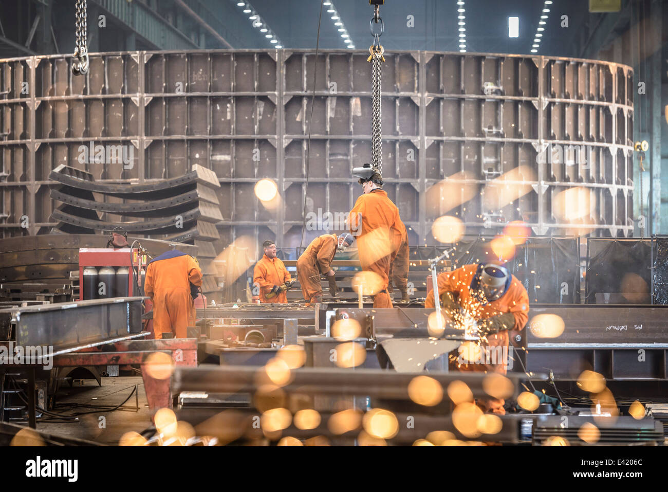 Workers grinding metal construction in marine fabrication factory Stock Photo