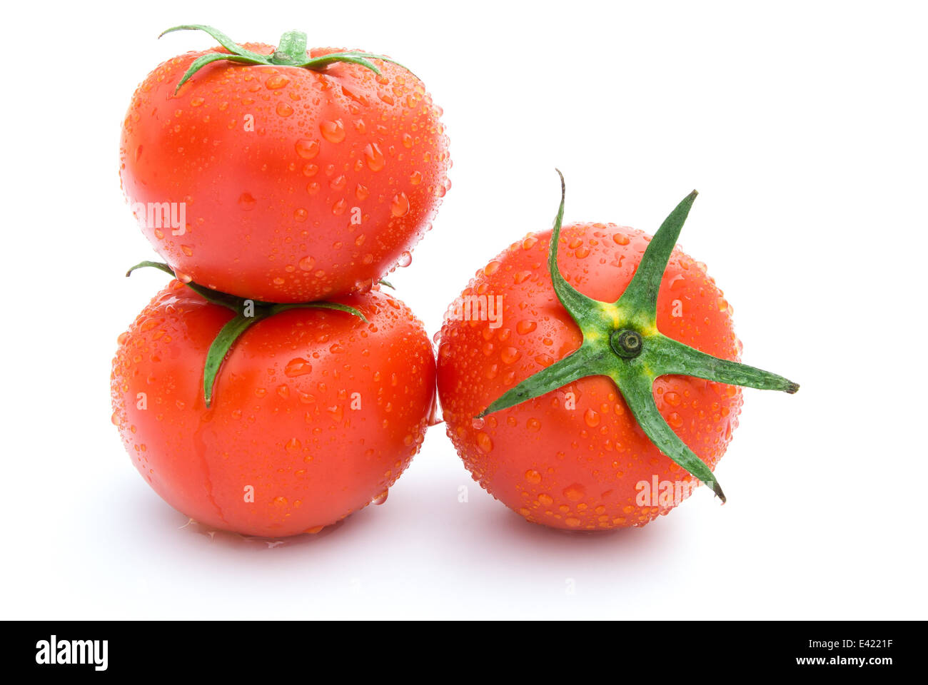 three fresh tomatoes on a white background Stock Photo - Alamy
