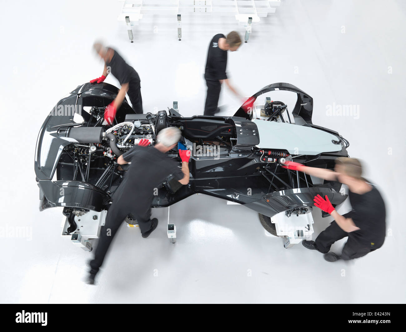 Engineers assembling supercar in sports car factory, overhead view Stock Photo