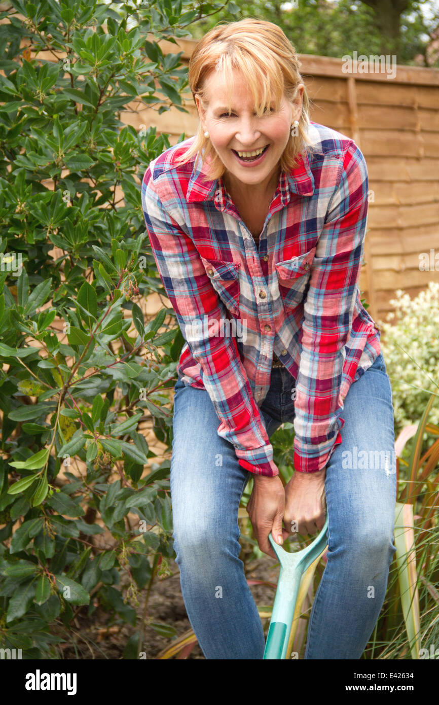 Portrait of mature woman having fun digging garden Stock Photo