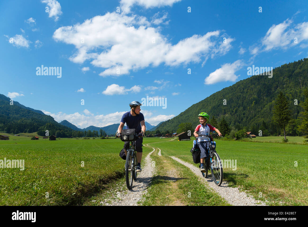 Father and son cycling through Jachenau, Bavaria, Germany Stock Photo