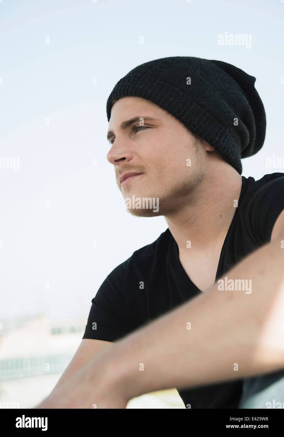 Portrait of young man wearing black tshirt and knit hat Stock Photo
