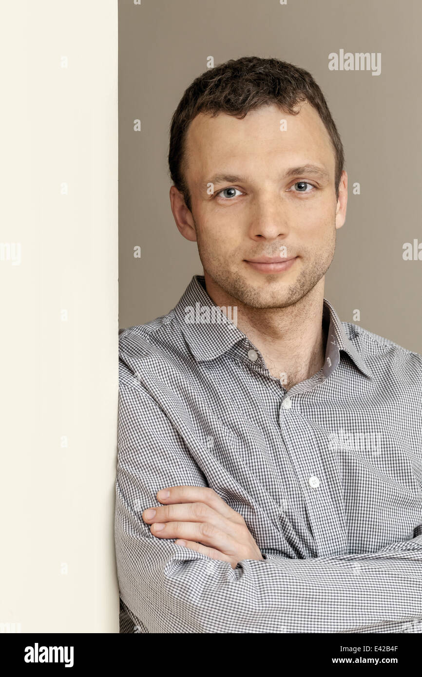 Young Caucasian Man, studio portrait with gray wall Stock Photo