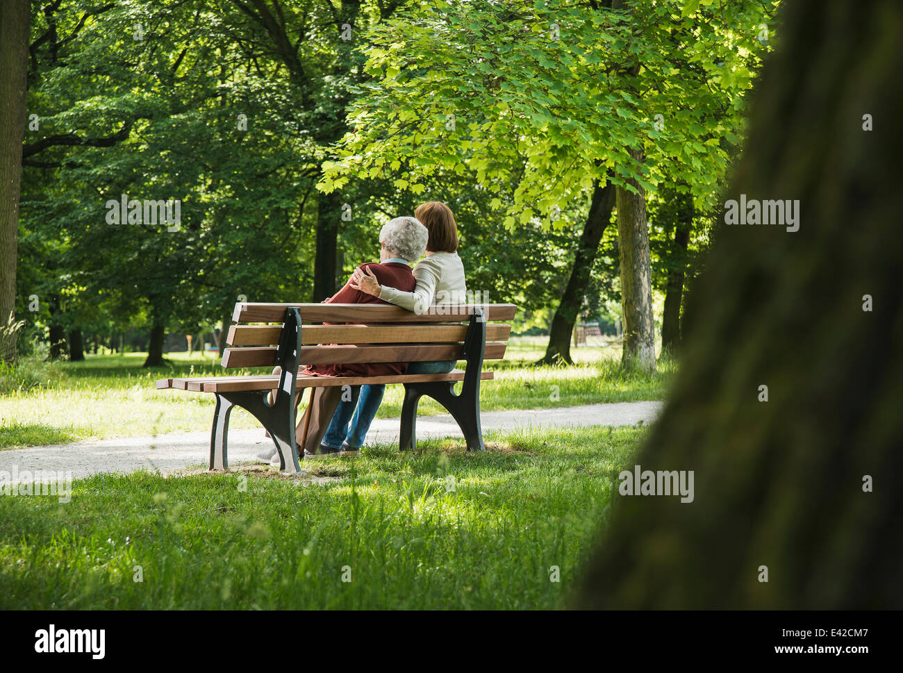 Senior woman sitting on park bench with granddaughter Stock Photo - Alamy