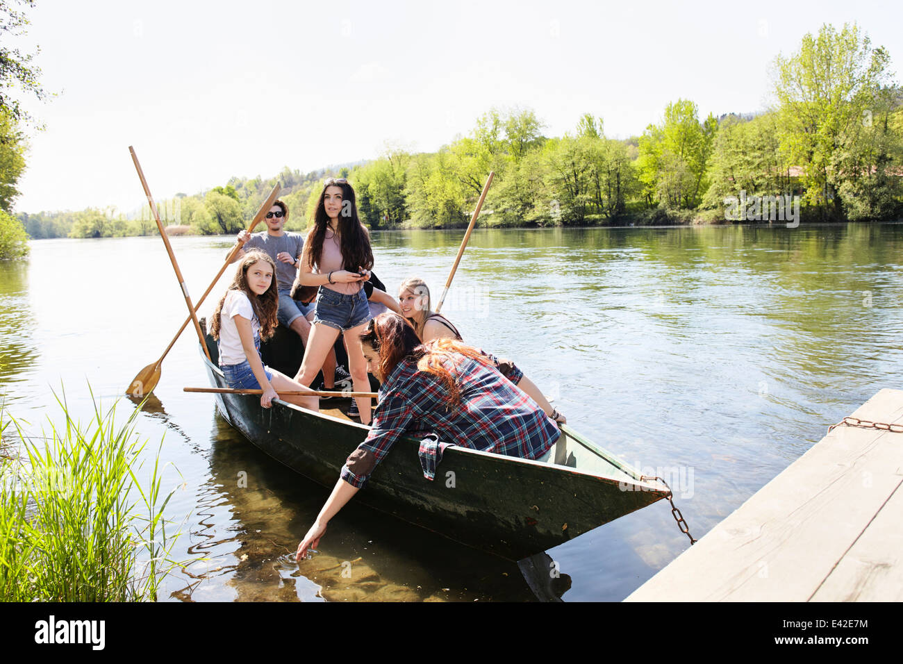 Group of friends in a row boat Stock Photo