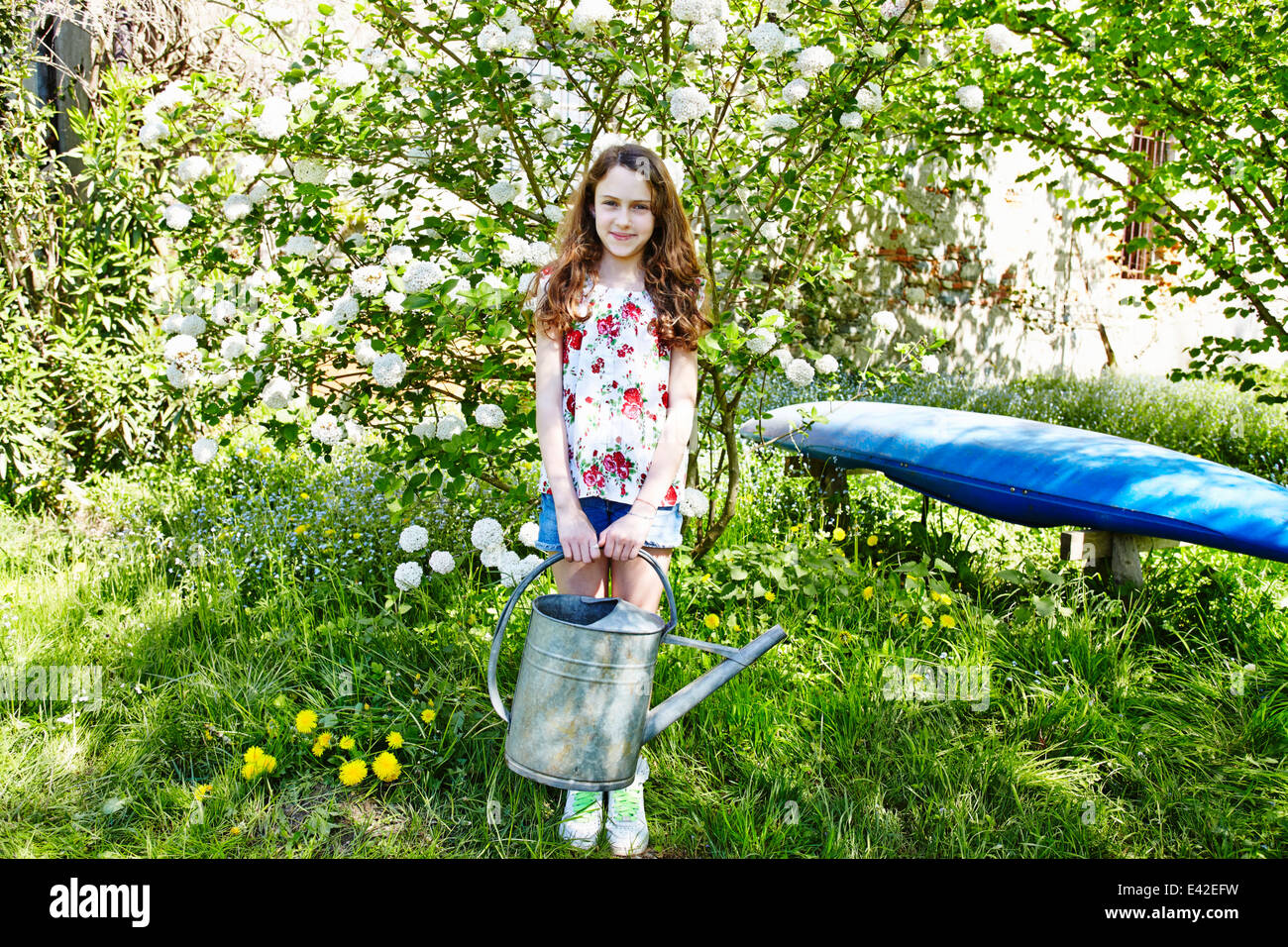 Girl holding watering can, portrait Stock Photo