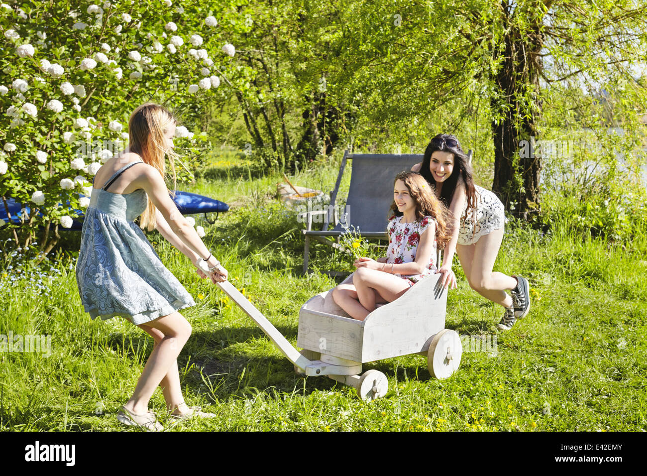 Young women playing with toy cart Stock Photo