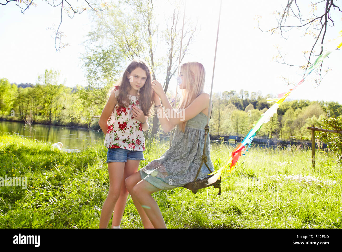 Young woman on swing with friend Stock Photo