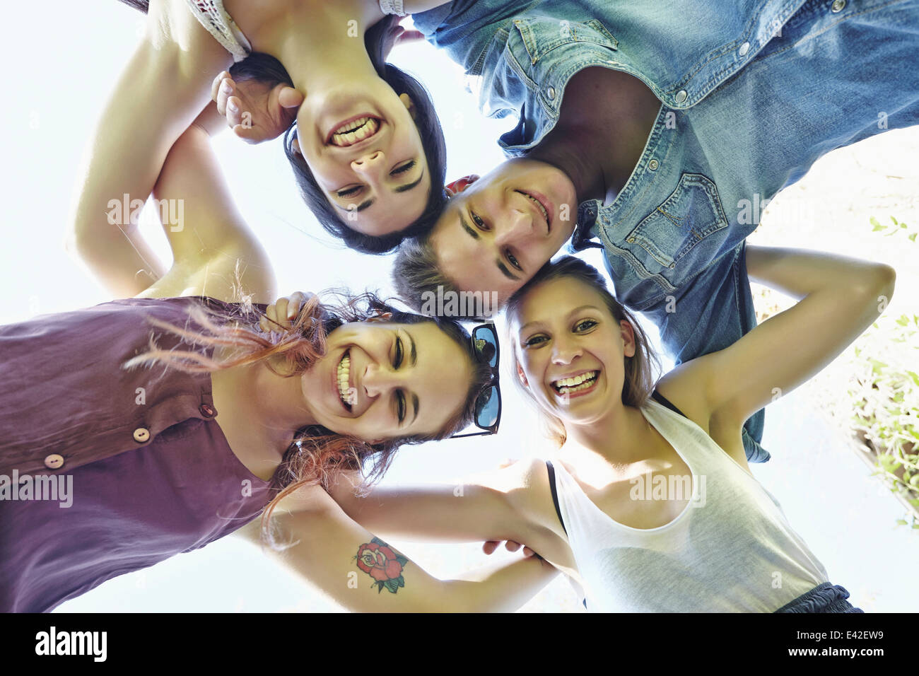 Group of friends in huddle smiling, low angle Stock Photo